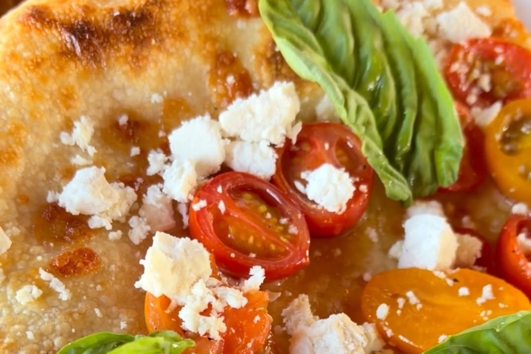 A Fluid State sourdough slice with cherry tomatoes and fresh basil